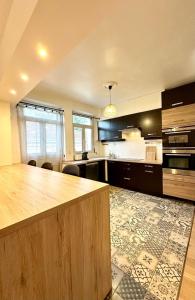 a large kitchen with a large wooden counter top at L'Évasion - Centre-Ville & Garage Privé in Mont-de-Marsan