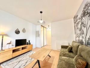 a living room with a couch and a tv at Le Vert D'eau - Raffiné - Central - Balcon in Mont-de-Marsan +29 photos