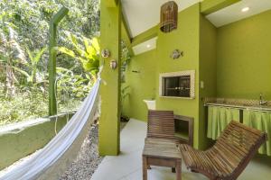 a room with a hammock and a table and a chair at Pousada Vila do Bosque in Bombinhas