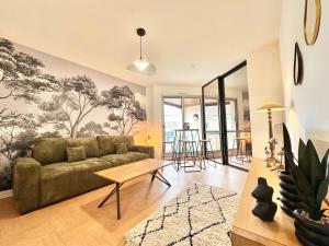 a living room with a couch and a table at Le Vert D'eau - Raffiné - Central - Balcon in Mont-de-Marsan
