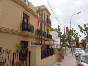 a building on a street with a flag on it at H Nieves Playa in Chipiona