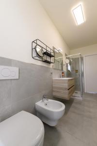 a white bathroom with a toilet and a sink at Hillside House Sant'Andrea in Vittorio Veneto +77 photos