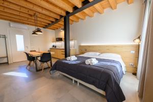 a bedroom with a bed and a table and a kitchen at Hillside House Sant'Andrea in Vittorio Veneto