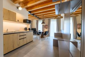 a kitchen with wooden cabinets and a dining room at Hillside House Sant'Andrea in Vittorio Veneto
