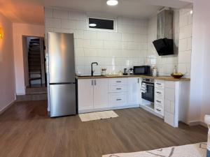 a kitchen with white cabinets and a stainless steel refrigerator at Las eras 84 in Níjar