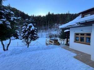 a snow covered yard next to a house at Vila Dom pod Chopkom in Bystrá