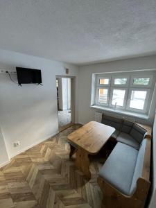 a living room with a wooden table and a couch at Vila Dom pod Chopkom in Bystrá