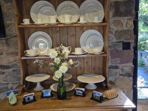a shelf with plates and cups and a vase with flowers at The Old Mill Annexe in Jacobstowe +101 photos
