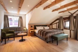 a bedroom with a bed and a couch and a table at Alpin Lifestyle Hotel Löwen & Strauss in Oberstdorf