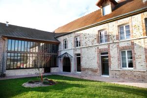 a large brick building with a lawn in front of it at Gîte de la Crayère in Gionges