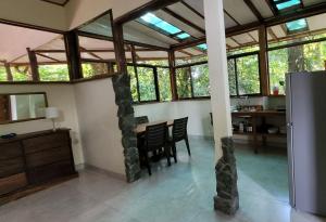 a dining room with a table and some windows at Nature Lovers Quepos in Quepos
