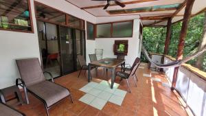 a screened in porch with a table and chairs at Nature Lovers Quepos in Quepos +55 photos