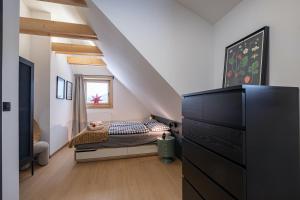 a bedroom with a bed with a dresser and a window at Chata Jarabina in Terchová