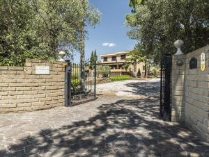 a gate to a driveway with a house in the background at Bed and Breakfast La Corte degli Ulivi in Civitavecchia