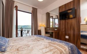 a hotel room with a bed and a television at Apartments Villa Kresic in Neum