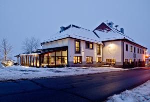 a large white building in the snow at night at Euler Neuschönau - 4 Sterne Superior Hotel in Neuschönau