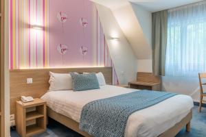 a bedroom with a bed and a pink wall with flowers at The Originals City, Hôtel Les Océanes, Lorient in Lorient