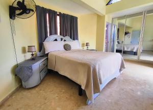 a bedroom with a large bed and a mirror at Refugio Encantador in Santo Domingo