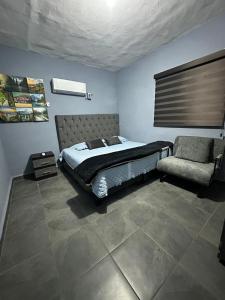 a bedroom with a bed and a chair at Departamento Mateos 503 in Ciudad Acuña