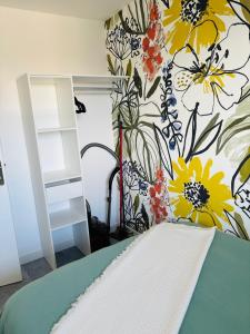a bedroom with a flower mural on the wall at sunset lodge calais in Calais
