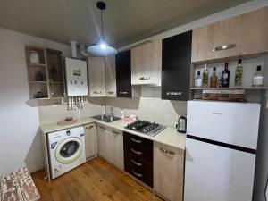 a kitchen with a white refrigerator and a dishwasher at Autøgráph Boutique Høme 9 in Borjomi +24 photos