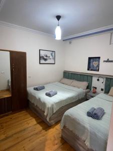 a bedroom with two beds and a light fixture at Autøgráph Boutique Høme 9 in Borjomi