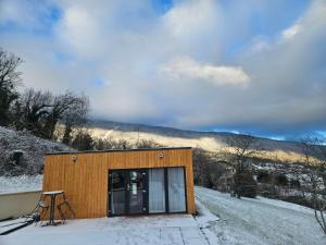 a small cabin with a table and chairs in the snow at Le Petit Chalet in Saint-Jorioz