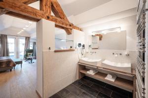 a bathroom with a large mirror and a sink at Alpin Lifestyle Hotel Löwen & Strauss in Oberstdorf +31 photos