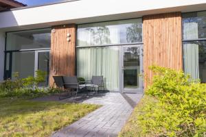 a patio with chairs and a table in front of a house at Giruliai loft in Klaipėda
