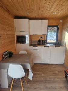 a kitchen with white cabinets and a table in a room at Le Petit Chalet in Saint-Jorioz