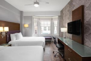 a hotel room with two beds and a flat screen tv at Cartwright Hotel Union Square - BW Premier Collection in San Francisco
