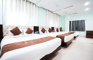 a hotel room with three beds in a room at Hotel Dosa plaza in Udaipur +78 photos