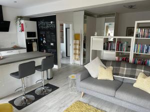 a living room with a couch and a bar in it at The Studio in Dunfermline