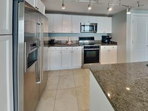 a kitchen with white cabinets and stainless steel appliances at Palisade Palms TW1012 - Sea Escape in Galveston +40 photos