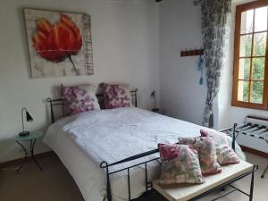 a bedroom with a bed and a table with pillows at Le Presbytère Bed & Breakfast in Saint-Romain