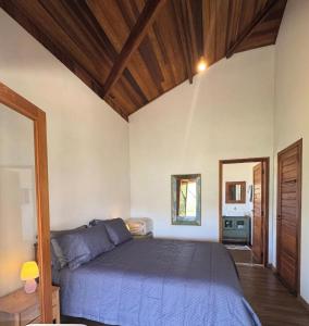 a bedroom with a bed in a room with wooden ceilings at Chalé Bem-te-vi Vista espetacular da Serra da Mantiqueira in São José dos Campos