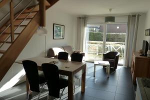 a dining room with a table and chairs and a staircase at Gite Opaline in Wimereux