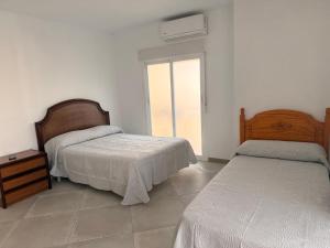 a bedroom with two beds and a window at Habitación Doble con Aire cerca de la Playa in Benidorm
