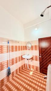 a room with a wooden floor with a sink and a mop at Serenyaa in Dibrugarh +2 photos
