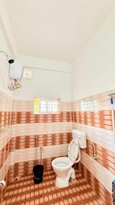 a bathroom with a toilet and a bath tub at Serenyaa in Dibrugarh