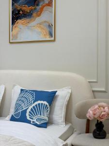 a blue and white pillow on a bed with a chair at Prime Stay Almaty & VIP Apartment in the center in Almaty