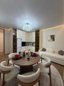 a living room with a table and chairs and a couch at Prime Stay Almaty & VIP Apartment in the center in Almaty