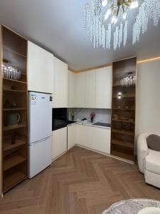 a kitchen with white cabinets and a white refrigerator at Prime Stay Almaty & VIP Apartment in the center in Almaty +38 photos