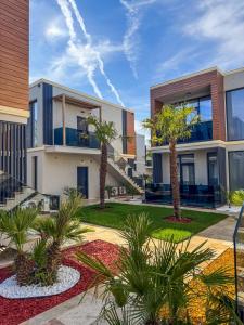 a building with palm trees in front of it at Office Villas Costinesti in Costinesti