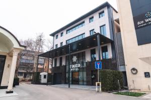 a building with a parking sign in front of it at Rauza Hotel Tashkent in Tashkent