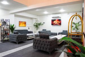a waiting room with chairs and a table and a fireplace at Rauza Hotel Tashkent in Tashkent