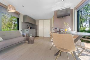 a kitchen and living room with a table and a couch at Houseboats Pean-buiten Weidum in Weidum +29 photos