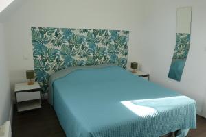 a bedroom with a bed with a blue blanket at Gite Opaline in Wimereux