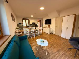 a living room with a blue couch and a table at Forest House Buxusson in Dolní Slověnice