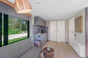 a living room with a couch and a large window at Houseboats Pean-buiten Weidum in Weidum
